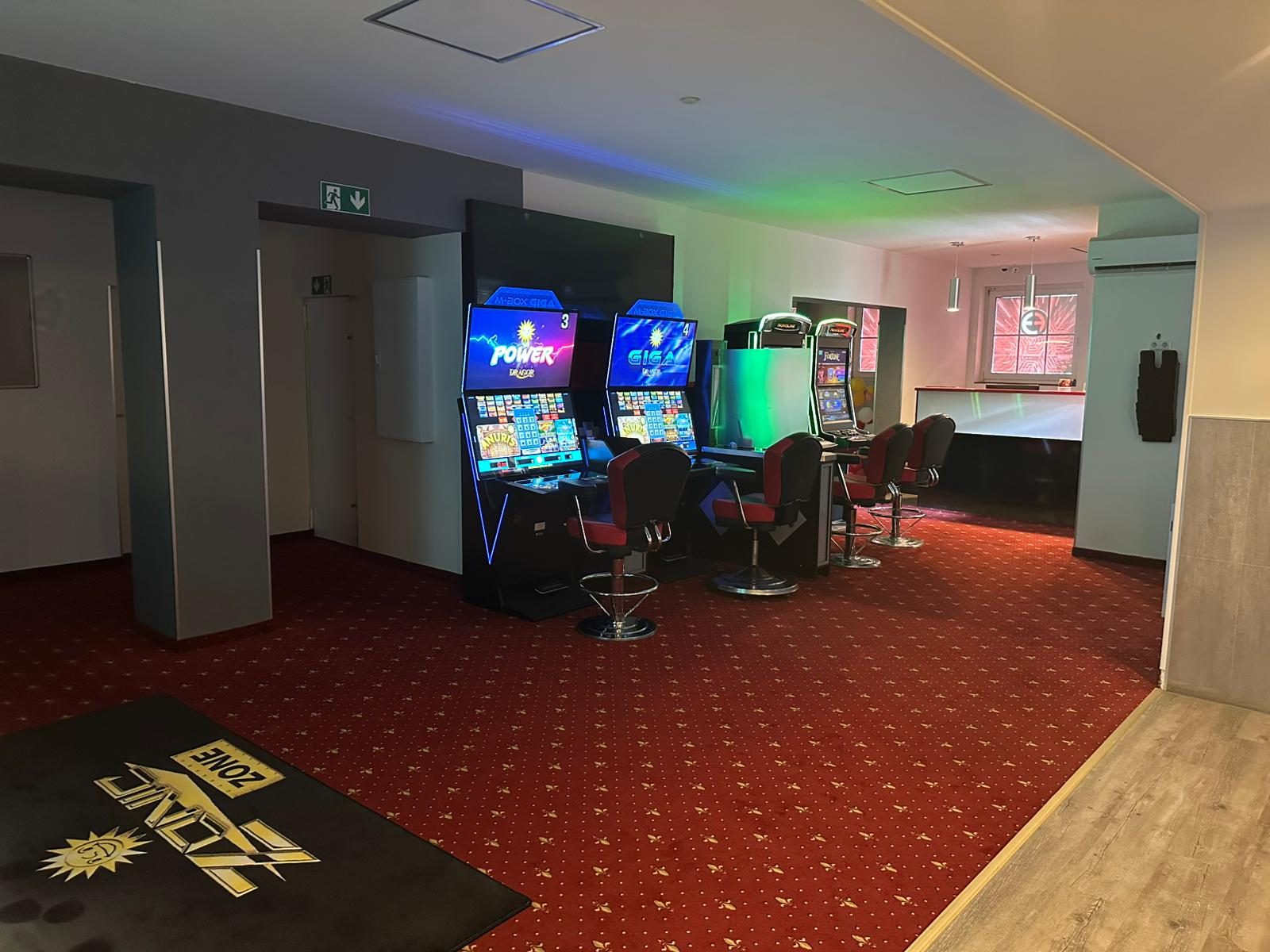 Spielbereich der Spielhalle Viersen mit farbiger Beleuchtung und rotem Teppich